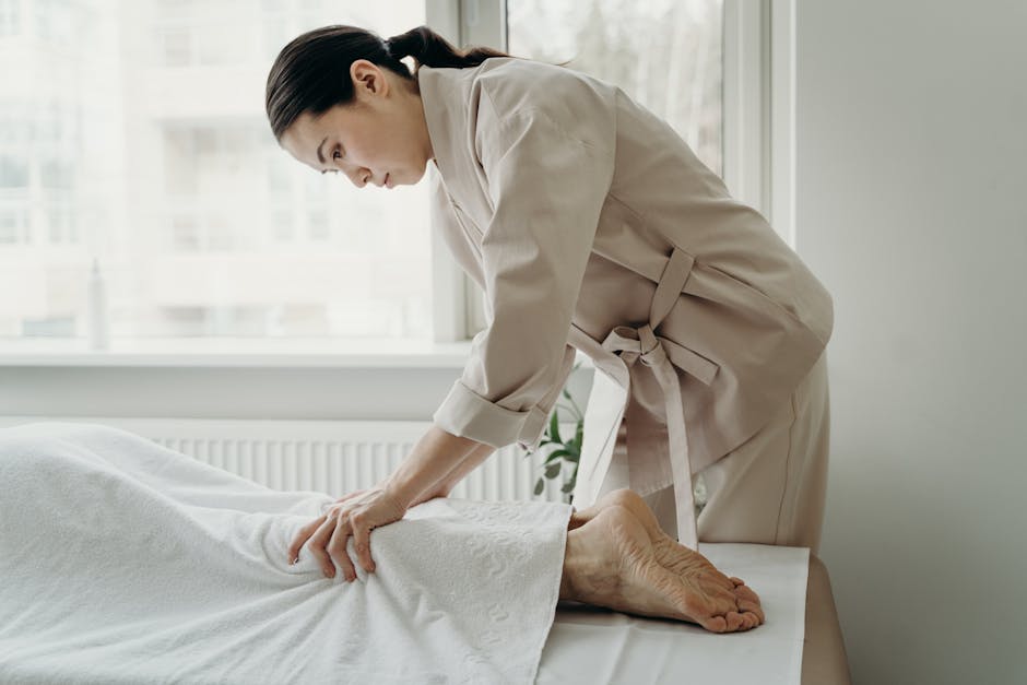 Asian female therapist providing a relaxing massage at a serene spa setting indoors.