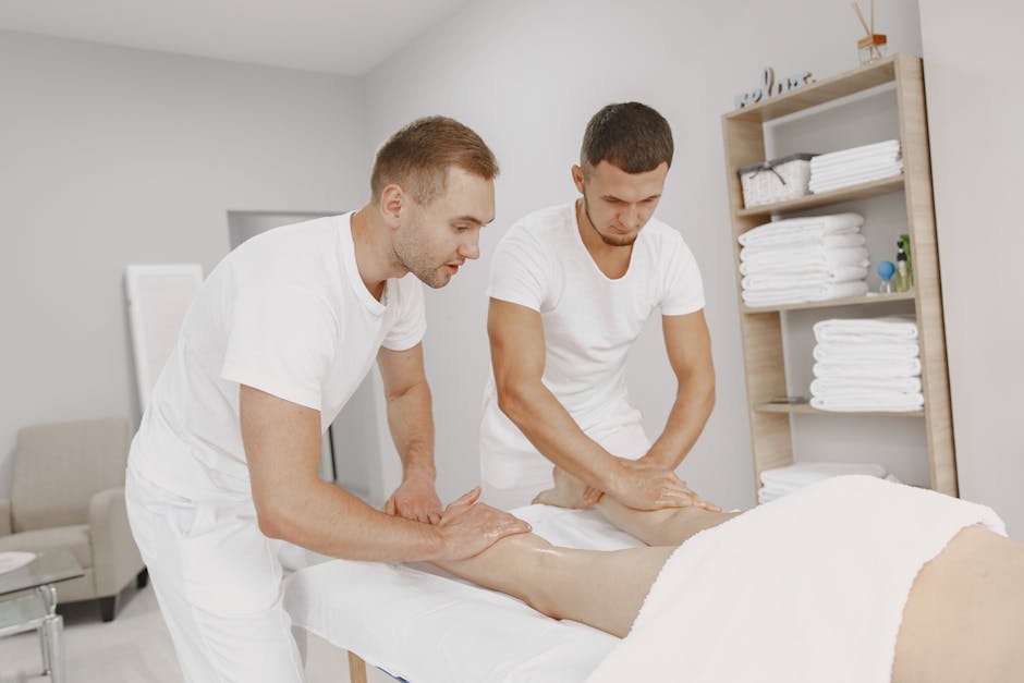 Two male therapists providing leg massage in a tranquil spa environment.